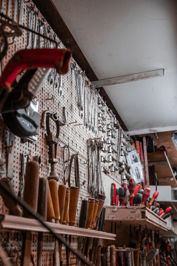 A workshop wall filled with various tools hanging for easy access and organization.