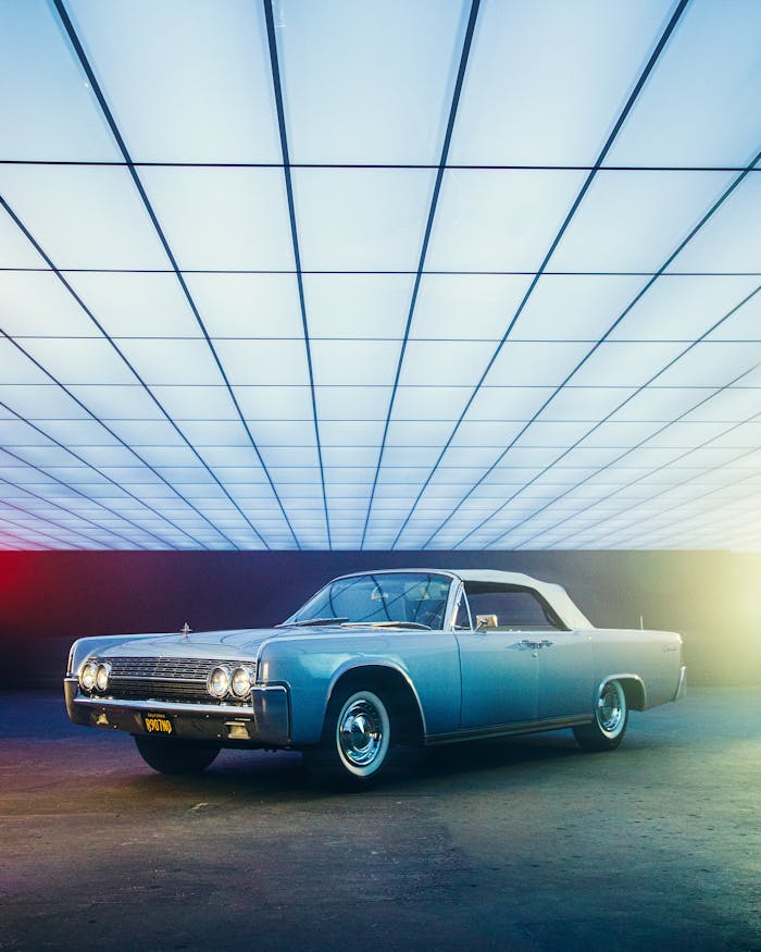 pexels photo 3156482 A vintage classic car displayed indoors with modern lighting, showcasing style and elegance.