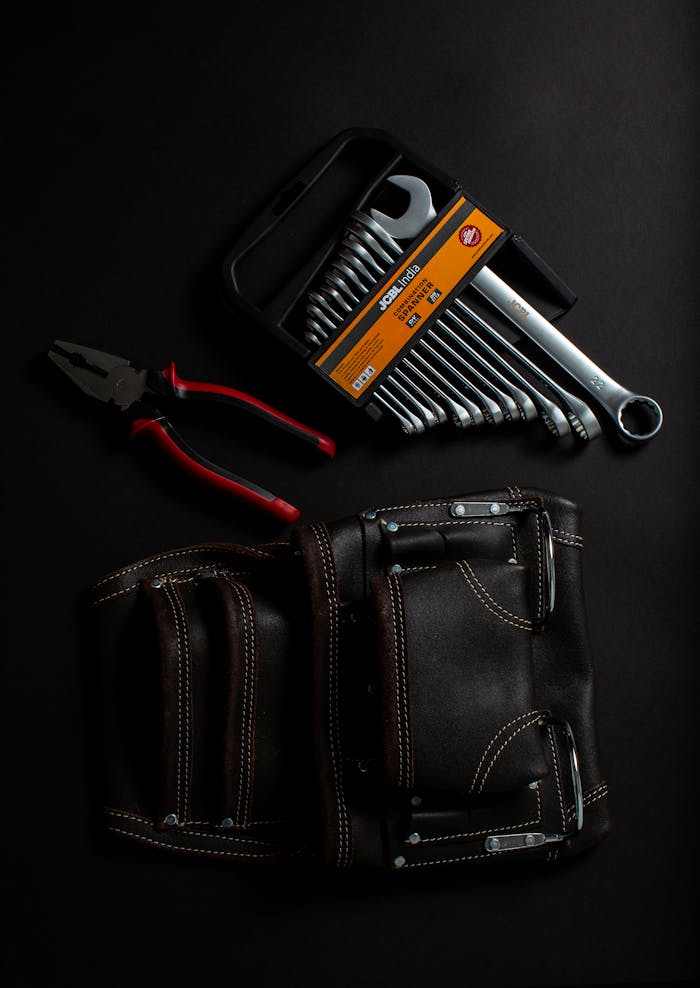 Premium hand tools and leather tool belt arranged on a dark surface. Ideal for projects.