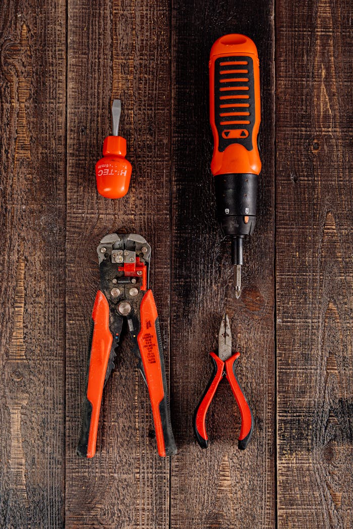 Flat lay view of various red tools on a wooden surface, perfect for DIY and workshop themes.